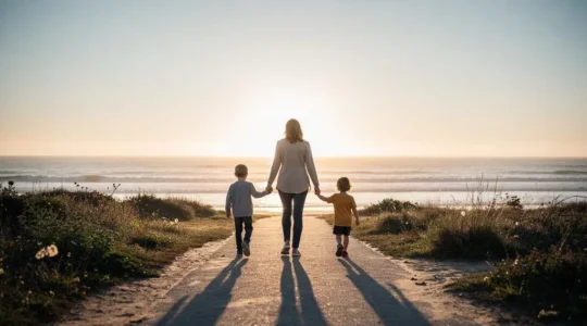 Famille marchant sereinement sur un chemin cotier au lever du soleil, symbolisant la protection financiere apportee par un capital deces
