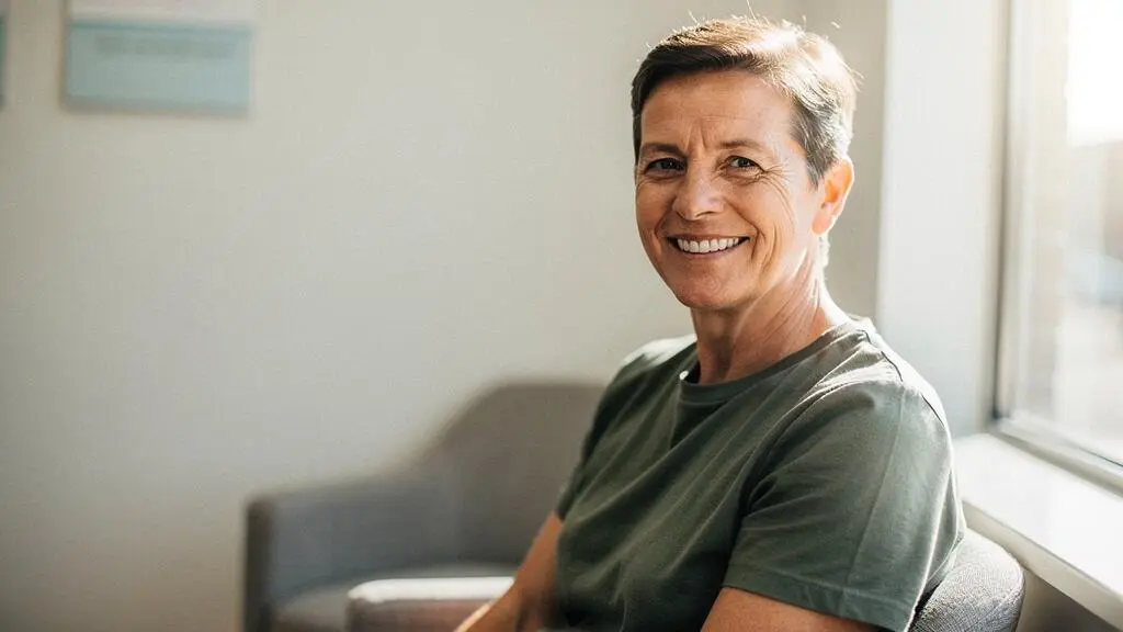 Portrait d'une personne souriante confiante illustrant la reconstruction dentaire accessible grace au dispositif 100% Sante
